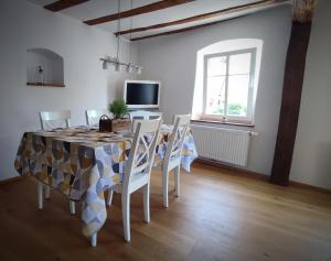 a dining room with a table and chairs and a television at Ferienwohnung La Maison Palatinate in Kapsweyer