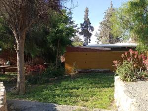 a garden with a yellow fence and trees at La Pirquita in Tilcara +13 photos