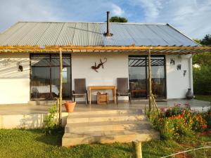 a cottage with a metal roof and a patio at Sani Pass View Cottage in Himeville