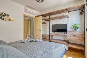 a bedroom with a bed and a tv in it at Magic view - Apartment with Pool in Budva +19 photos