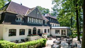 een groot wit huis met tafels en stoelen bij Hotel Münnich in Münster
