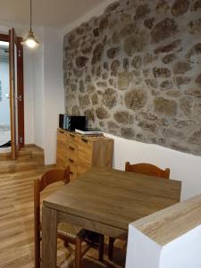 a dining room with a table and chairs and a stone wall at B&B Daniela in Darfo