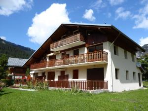 een groot huis met een balkon en een grasveld bij Chaleureux Appartement 3 Pièces à 400m du Téléphérique - FR-1-464-150 in Pralognan-la-Vanoise +8 foto's