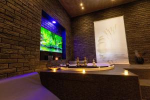 a room with a tub with a tv on a brick wall at Lungomare Suite & Spa in Naples