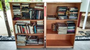a book shelf filled with lots of books at Patini Bungalows - Beach Garden in Tangalle