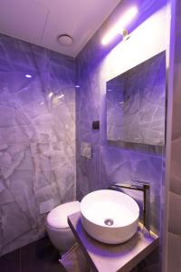a bathroom with a white sink and a toilet at Lungomare Suite & Spa in Naples