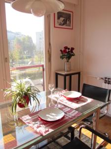 uma sala de jantar com uma mesa de vidro e uma janela em Apartment Grado em Zagreb