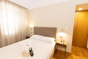 a bedroom with a bed with a remote control on it at Lungomare Suite & Spa in Naples