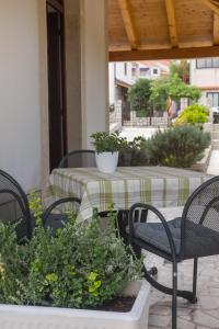 a patio with a table and chairs and plants at Apartments Franjo in Mali Lošinj