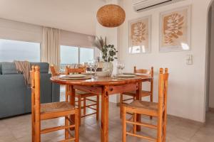 a dining room with a wooden table and chairs at Apartamento Blaucel in L'Escala