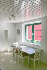 ein Esszimmer mit einem Tisch, Stühlen und einem Fenster in der Unterkunft Ferienhaus Drewitz (EOC-FUP 07/2017) in Drewitz