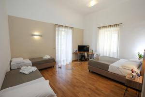 a hotel room with two beds and a television at Lungomare Suite & Spa in Naples