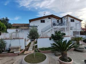 a white building with a staircase and some plants at New house in Qualiano