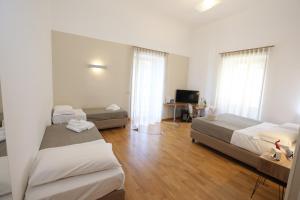 a hotel room with two beds and a television at Lungomare Suite & Spa in Naples