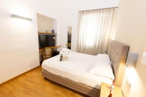a small bedroom with a bed and a window at Lungomare Suite & Spa in Naples