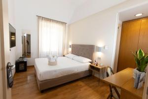 a bedroom with a bed and a table and a desk at Lungomare Suite & Spa in Naples