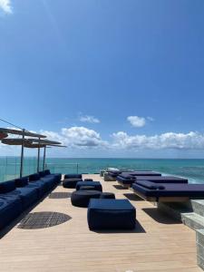 eine Reihe von Liegen am Strand mit Meerblick in der Unterkunft beira-mar pajuçara in Maceió