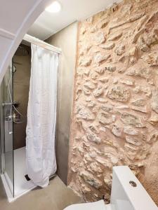 a bathroom with a shower and a stone wall at Casa Rural Gandia in Bocairent +40 photos