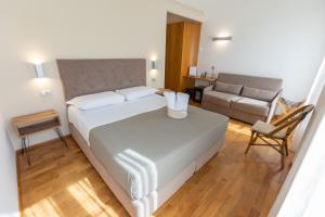 a bedroom with a large white bed and a couch at Lungomare Suite & Spa in Naples