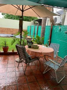 a table and chairs with an umbrella on a patio at DAS THOMY II in Córdoba