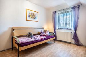 a bedroom with a bed with purple sheets and a window at Ferienwohnung über 2 Etagen in Trollenhagen