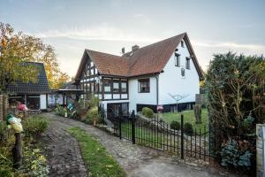 a white and black house with a fence at Ferienwohnung über 2 Etagen in Trollenhagen