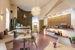 a living room with tables and chairs and a chandelier at Lungomare Suite & Spa in Naples