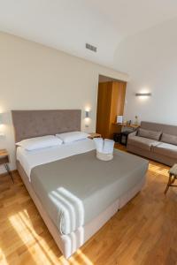 a bedroom with a large white bed and a couch at Lungomare Suite & Spa in Naples