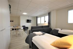 Habitación con 2 camas y comedor. en Forenom Aparthotel Kuopio, en Kuopio