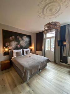 a bedroom with a large bed with a painting on the wall at Villa Burgau, C&H in Monschau