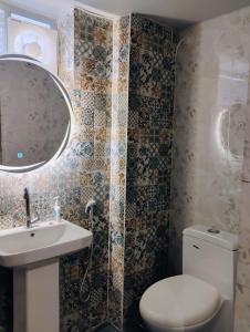 a bathroom with a toilet and a sink and a mirror at Bharat Milap Home Stay in Varanasi