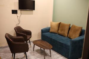 a living room with a blue couch and two chairs at Bharat Milap Home Stay in Varanasi
