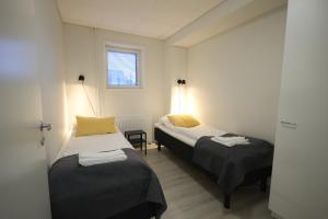 Un dormitorio con dos camas y una ventana. en Forenom Aparthotel Kuopio, en Kuopio