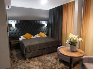 ゴジュフ・ヴィエルコポルスキにあるHotel Mieszkoのベッドとテーブルとソファのある寝室