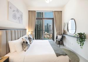 a bedroom with a bed and a large window at Burj Crown Luxury 4 Bedroom, Balcony Views, 5 min to Burj Khalifa in Dubai