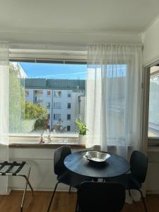 a dining room with a table and a large window at Bright Studio, Central Helsinki in Helsinki