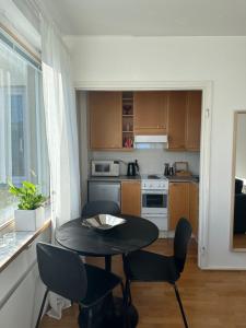 a small kitchen with a table and chairs in a room at Bright Studio, Central Helsinki in Helsinki +6 photos