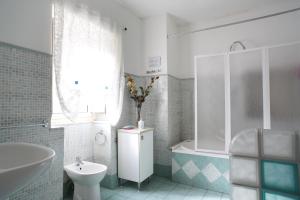 a bathroom with a tub and a toilet and a sink at Piccadilly House in Catania