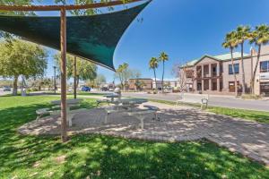 a group of picnic tables and benches in a park at Stylish and Prestigious - 2 Bed, 2 Bath On The Avenue in Fountain Hills