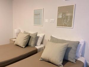 Un dormitorio con dos camas con almohadas y un cuadro en la pared. en Bravo Suites en el casco histórico de Salta, p/ 2., en Salta