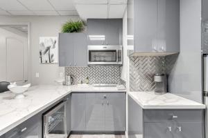 a white kitchen with a sink and a microwave at Stylish and Prestigious - 2 Bed, 2 Bath On The Avenue in Fountain Hills