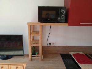 a microwave sitting on a table next to a tv at Le Cocon des Carroz, au centre de la station et proximité des pistes, apt 4 pers in Arâches-la-Frasse