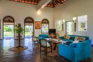 ウナワトゥナにあるPrana Villa Unawatuna - Charming 4 bedroom Villaの青いソファとテーブルのあるリビングルーム