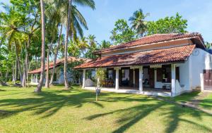 ウナワトゥナにあるPrana Villa Unawatuna - Charming 4 bedroom Villaの庭前のヤシの木がある家