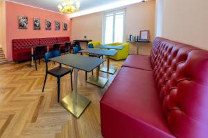 a waiting room with tables and a red couch at Sibilla Ospitalità in Visso