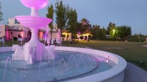a fountain in the middle of a pool at night at Portal del Nevado in General Alvear