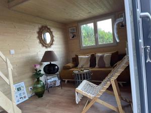 a living room with a couch and a table at Chalet charmant à Sainte-Marie-du-Mont avec terrasse in Sainte-Marie-du-Mont