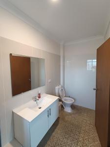 un bagno con un lavandino bianco e un water di Cozy Family Room with Private Bathroom in Spacious Home - M8 a Merrylands Altre 18 foto