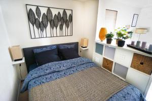 una camera da letto con un letto e un quadro sul muro di 2 pièces "Les Nuits Douces" - Calme et Lumineux - Gare à 10 min - Tram à 3 min a Le Havre