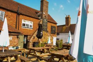 a group of picnic tables in front of a building at Rose and Crown B&B in Burwash